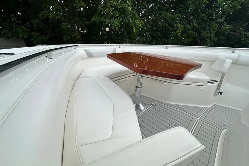  Yacht Photos Pics 2015 Boston Whaler 370 Outrage interior with white seating and wooden table.
