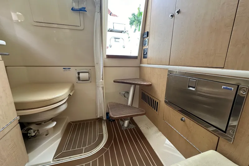  Yacht Photos Pics Interior of 2015 Boston Whaler 370 Outrage, featuring a compact marine bathroom.
