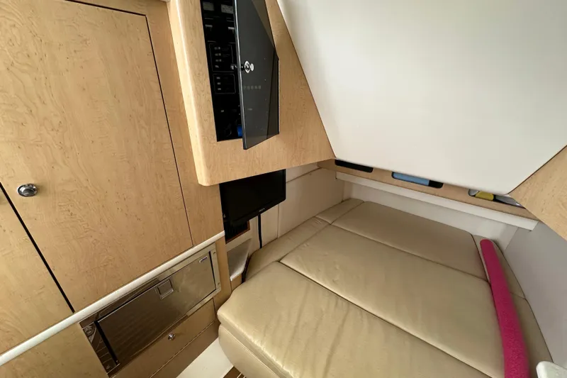  Yacht Photos Pics 2015 Boston Whaler 370 Outrage cabin interior with beige seating and wooden cabinetry.