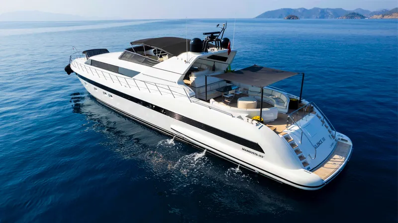  Yacht Photos Pics Luxurious 1999 Mangusta 105 yacht cruising on serene blue waters.