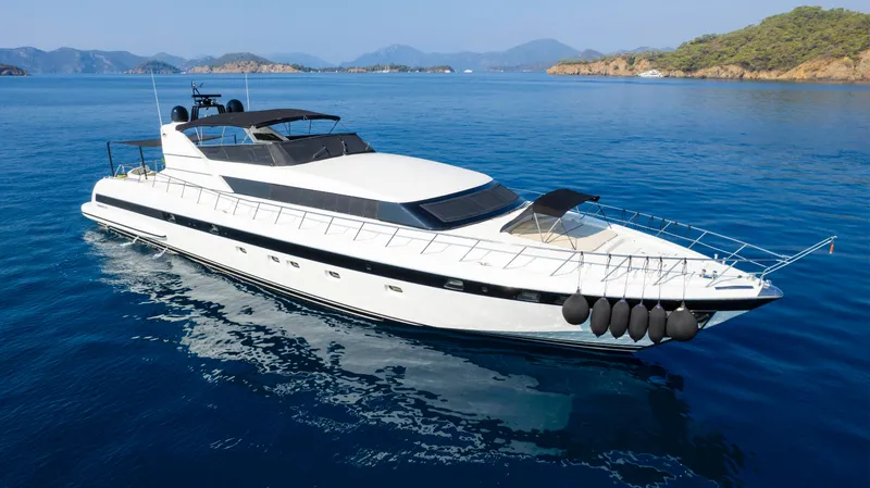  Yacht Photos Pics Luxurious 1999 Mangusta 105 yacht cruising in serene blue waters.