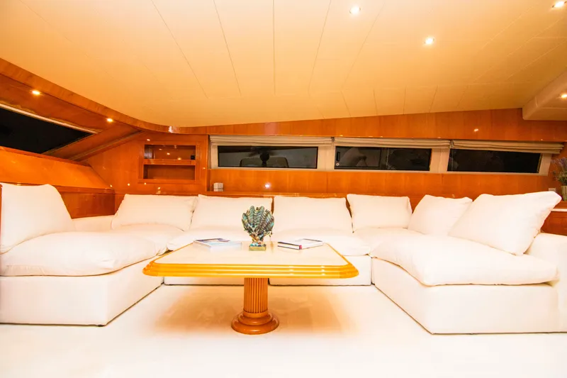  Yacht Photos Pics Luxurious interior of 1999 Mangusta 105 yacht with plush white seating and wooden accents.