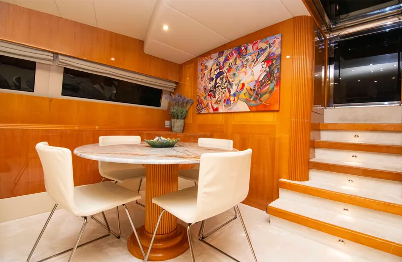  Yacht Photos Pics Luxurious dining area on 1999 Mangusta 105 yacht with modern decor and artwork.