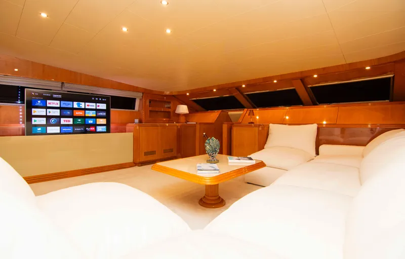  Yacht Photos Pics Luxurious interior of 1999 Mangusta 105 yacht with plush seating and modern entertainment system.