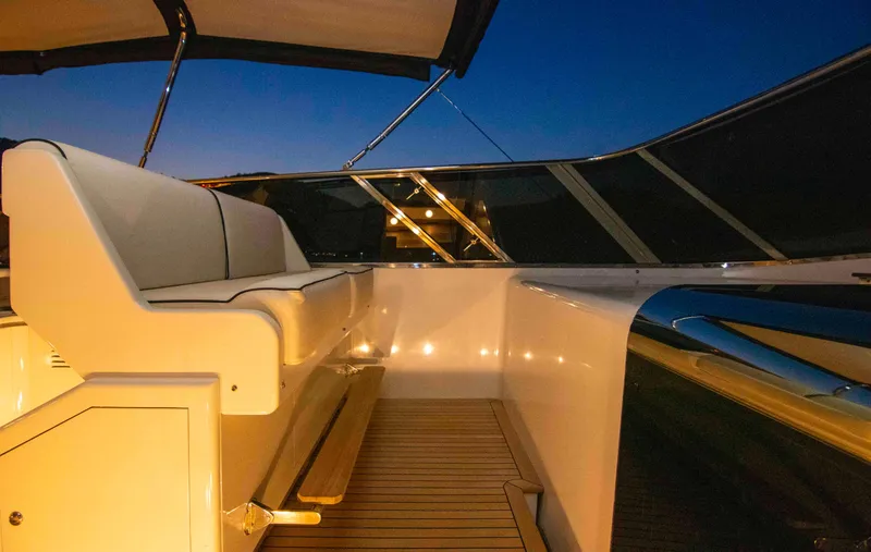  Yacht Photos Pics Luxurious 1999 Mangusta 105 yacht deck at sunset, featuring elegant seating and ambient lighting.