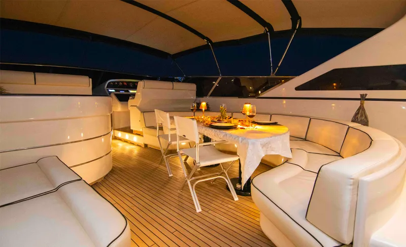  Yacht Photos Pics Luxurious 1999 Mangusta 105 yacht interior with elegant dining setup and ambient lighting.