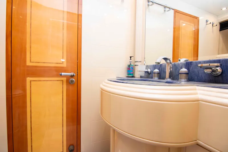  Yacht Photos Pics Luxurious bathroom in 1999 Mangusta 105 yacht with elegant sink and wooden door.