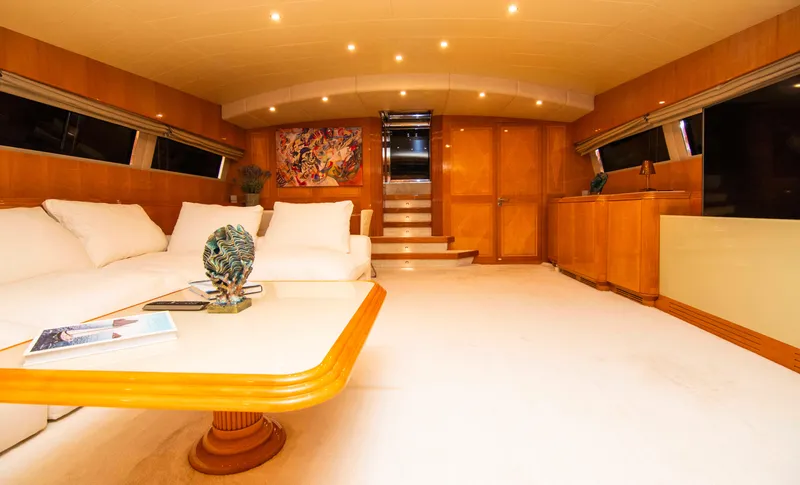  Yacht Photos Pics Luxurious interior of a 1999 Mangusta 105 yacht with elegant furnishings and warm lighting.