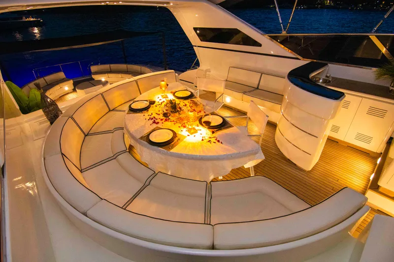  Yacht Photos Pics Luxurious 1999 Mangusta 105 yacht with elegant outdoor dining area, ambient lighting, and stylish seating.