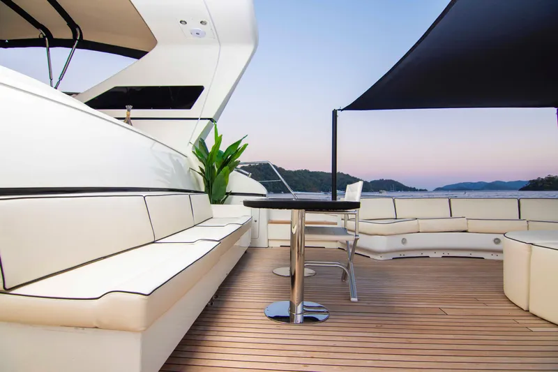  Yacht Photos Pics Luxurious 1999 Mangusta 105 yacht deck with elegant seating and scenic ocean view.