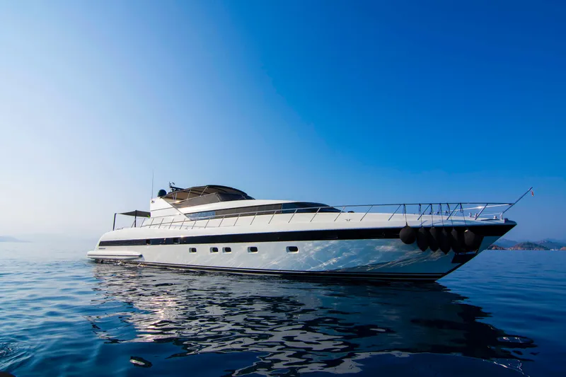  Yacht Photos Pics Luxurious 1999 Mangusta 105 yacht on calm blue waters under clear sky.