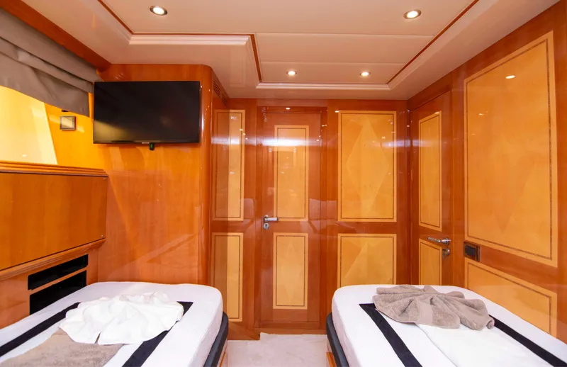  Yacht Photos Pics Luxurious 1999 Mangusta 105 yacht cabin with twin beds and elegant wood paneling.