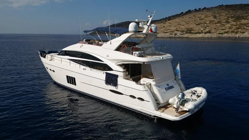  Yacht Photos Pics Luxurious 2012 Princess 72 yacht cruising in serene waters near a rocky coastline.