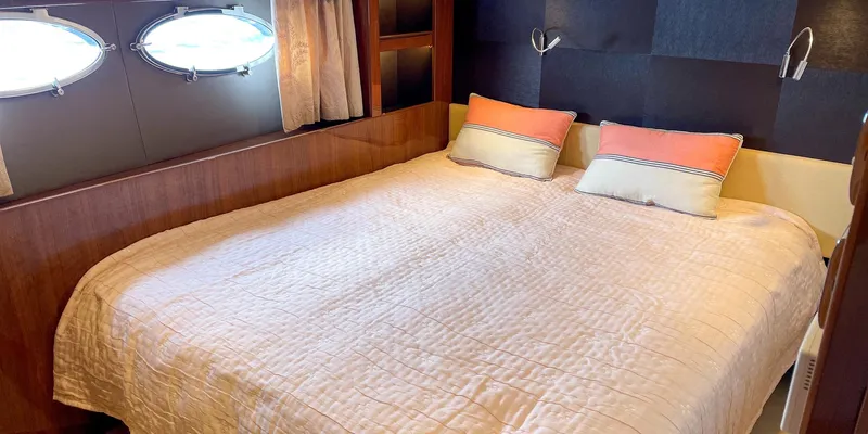  Yacht Photos Pics Luxurious bedroom interior of 2012 Princess 72 yacht with cozy bedding and porthole windows.