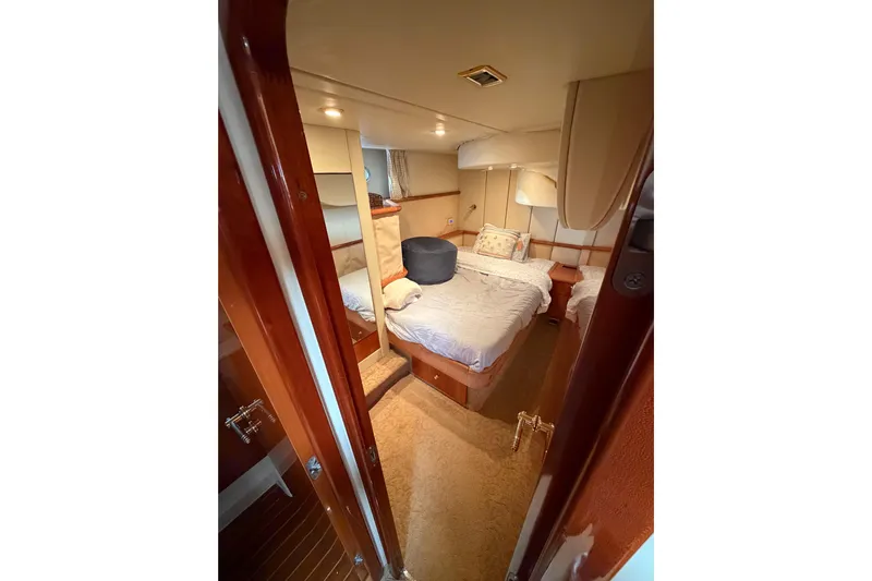 What Is Life Yacht Photos Pics Interior cabin of 2000 Sunseeker Manhattan 62 yacht, featuring cozy bed and elegant wood finishes.
