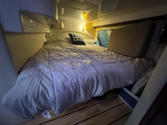 Outnumbered Yacht Photos Pics Cozy cabin bedroom in a 2015 Regal 42 Sport Coupe yacht with soft lighting.