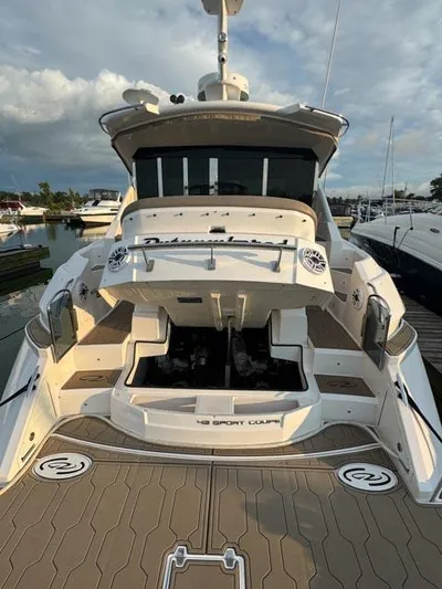 Outnumbered Yacht Photos Pics 2015 Regal 42 Sport Coupe yacht docked at marina, rear view with open engine compartment.