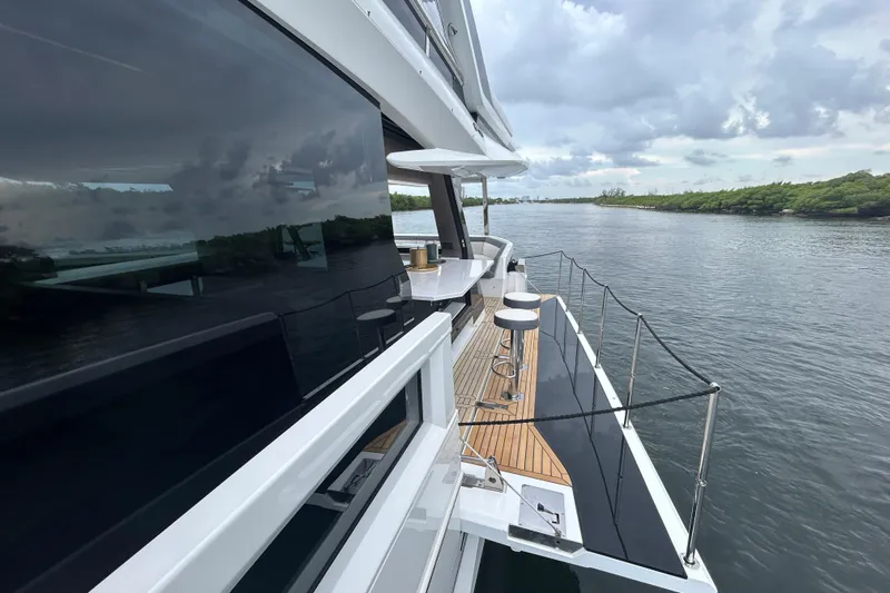  Yacht Photos Pics 2025 Galeon 640 Fly yacht with sleek design, docked on calm waters under cloudy skies.