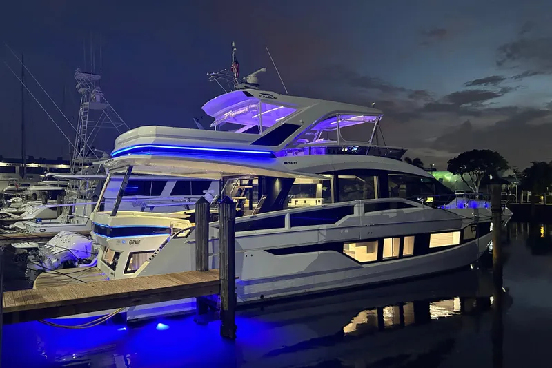 Yacht Photos Pics Luxurious 2025 Galeon 640 Fly yacht illuminated at night in a marina setting.