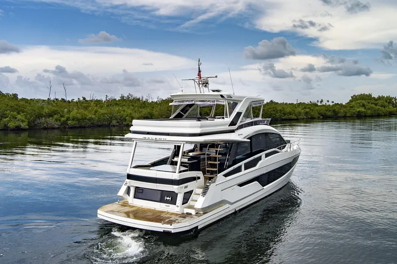  Yacht Photos Pics 2025 Galeon 640 Fly yacht cruising on calm waters under a partly cloudy sky.