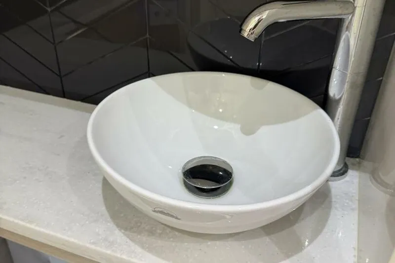  Yacht Photos Pics Modern white vessel sink with chrome faucet on a sleek countertop.