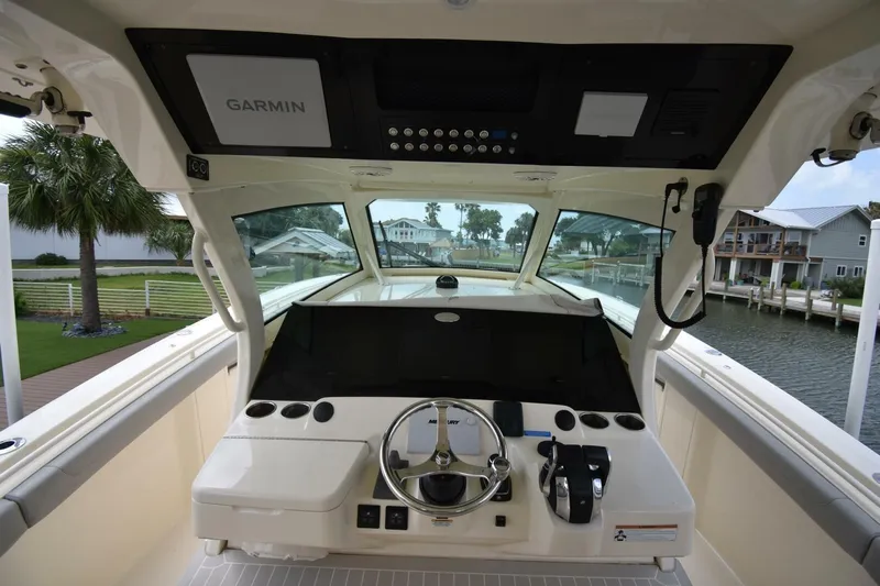  Yacht Photos Pics 2022 Scout 425 LXF boat helm with Garmin navigation system, docked by waterfront homes.