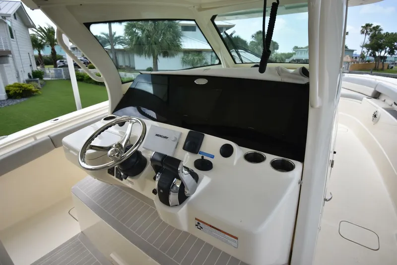  Yacht Photos Pics 2022 Scout 425 LXF boat helm with steering wheel and control panel.