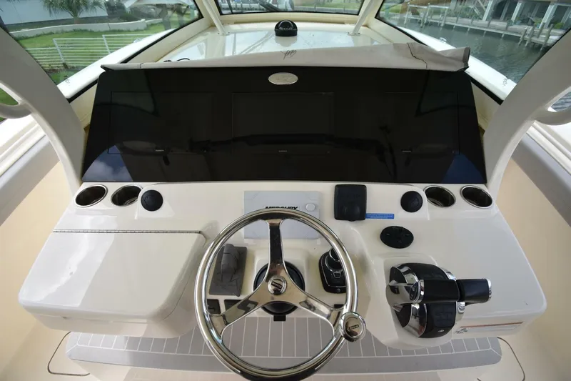  Yacht Photos Pics 2022 Scout 425 LXF boat helm with steering wheel and control panel.