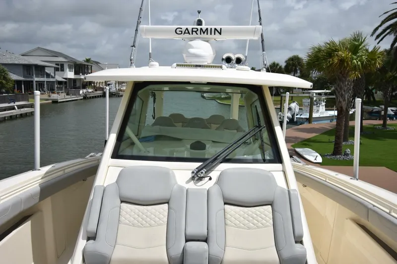  Yacht Photos Pics 2022 Scout 425 LXF boat with Garmin equipment, docked near waterfront homes and palm trees.