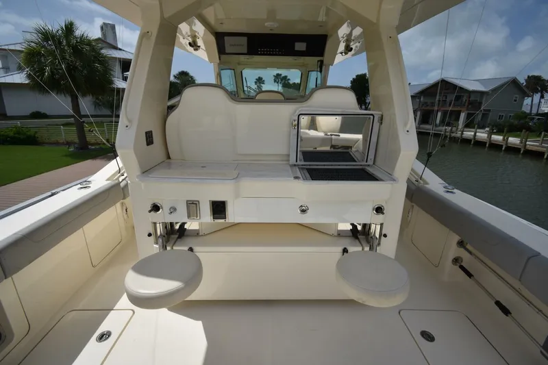  Yacht Photos Pics 2022 Scout 425 LXF boat interior with seating and grill, docked by waterfront homes.