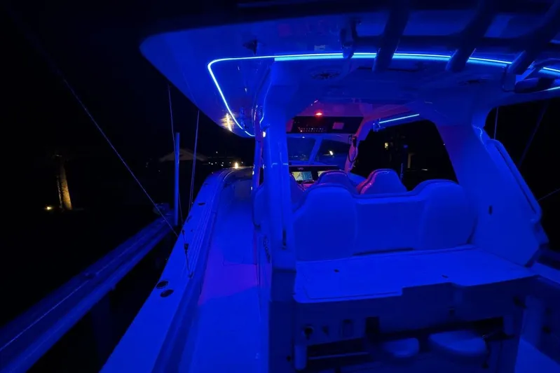  Yacht Photos Pics 2022 Scout 425 LXF boat illuminated with blue LED lights at night.
