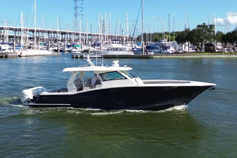  Yacht Photos Pics 2022 Scout 425 LXF boat cruising in a marina with sailboats in the background.