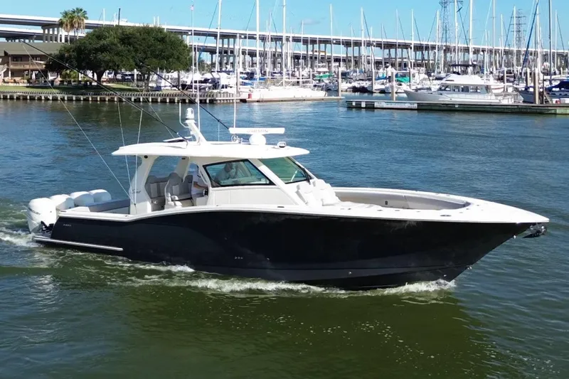  Yacht Photos Pics 2022 Scout 425 LXF boat cruising in a marina with sailboats in the background.