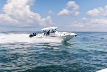  Yacht Photos Pics 2024 Fountain 32 NX speedboat cruising on open water under a clear sky.