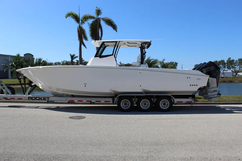  Yacht Photos Pics 2024 Fountain 32 NX boat on trailer, parked near palm trees.