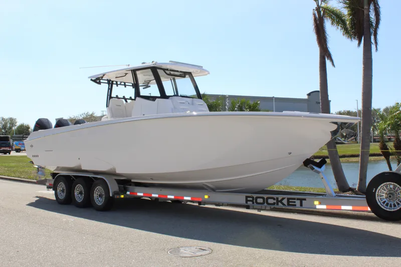  Yacht Photos Pics 2024 Fountain 32 NX boat on trailer, parked near palm trees.