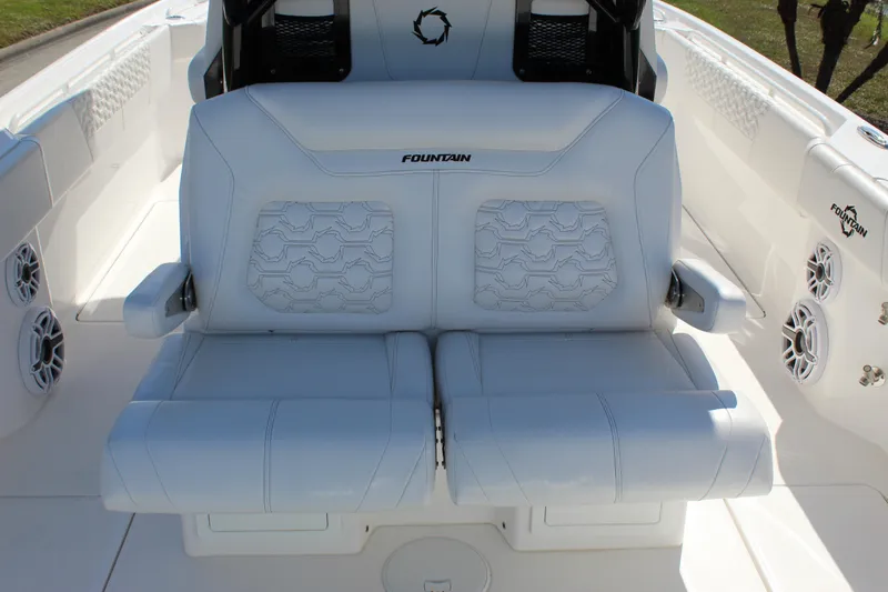  Yacht Photos Pics 2024 Fountain 32 NX boat interior with white cushioned seating and speaker system.