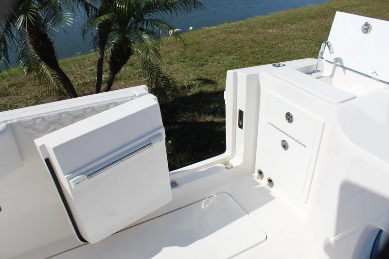  Yacht Photos Pics 2024 Fountain 32 NX boat interior with storage compartments and seating near water.