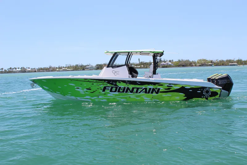  Yacht Photos Pics 2024 Fountain 32 NX boat with vibrant green design on calm water.