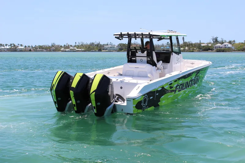  Yacht Photos Pics 2024 Fountain 32 NX boat with triple outboard engines cruising on clear blue water.