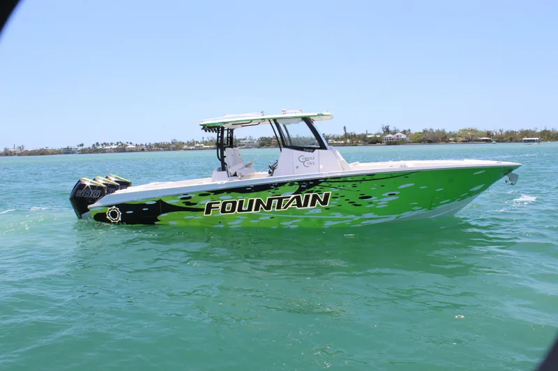  Yacht Photos Pics 2024 Fountain 32 NX boat on water, vibrant green design, clear sky background.