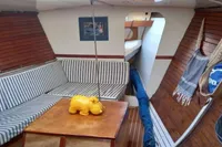 Interior of 1985 Cape Codder Coder Withbread 57 sailboat with striped seating and wooden accents.