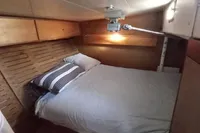 Cozy cabin interior of 1985 Cape Codder Coder Withbread 57 with wooden accents and bedding.