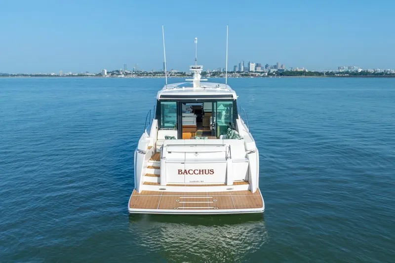 Bacchus Yacht Photos Pics 2022 Tiara Yachts Coupe on water, city skyline in background.