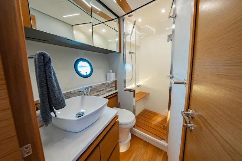 Bacchus Yacht Photos Pics Luxurious 2022 Tiara Yachts Coupe bathroom with modern fixtures and wooden accents.