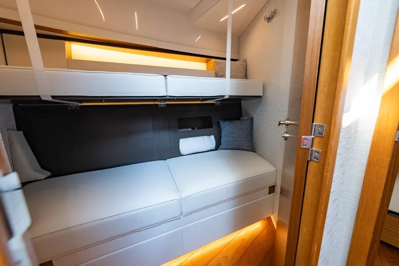 Bacchus Yacht Photos Pics 2022 Tiara Yachts Coupe interior cabin with modern bunk beds and elegant lighting.