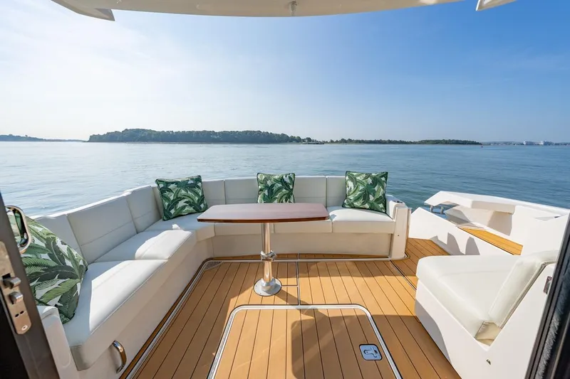 Bacchus Yacht Photos Pics Luxurious 2022 Tiara Yachts Coupe with elegant seating and scenic ocean view.
