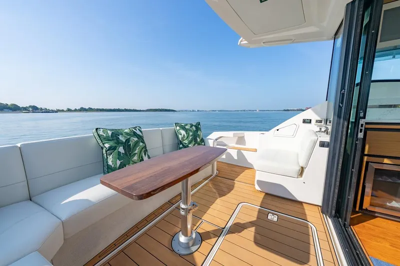 Bacchus Yacht Photos Pics Luxurious 2022 Tiara Yachts Coupe with elegant deck seating and scenic ocean view.