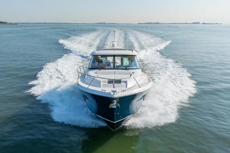 Bacchus Yacht Photos Pics 2022 Tiara Yachts Coupe cruising on open water, creating a dynamic wake.