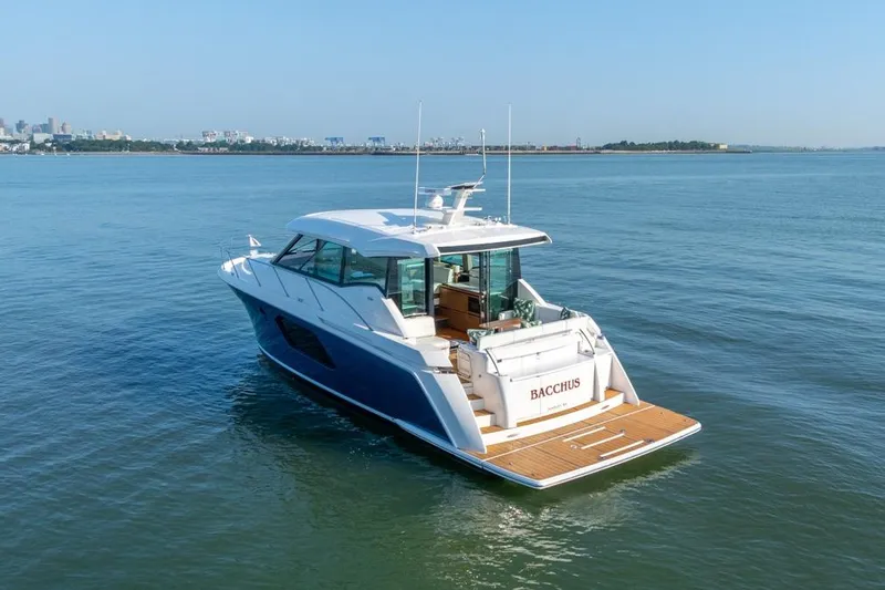 Bacchus Yacht Photos Pics 2022 Tiara Yachts C49 Coupe cruising on calm waters, rear view.